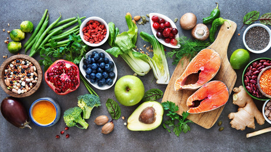 A colorful spread of healthy foods — salmon, avocado, berries, vegetables, and seeds — arranged on a table to represent balanced nutrition alongside the top berberine supplement for metabolic and heart health.